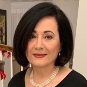 Woman with black bob haircut and pearls.