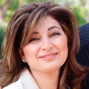 Smiling woman with wavy brown hair.