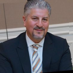 Man in a suit smiling at camera.